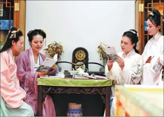  ??  ?? Top: Women dress in hanfu robes at a reading event held by the Beijing Mowu Tianxia Hanfu Associatio­n in December.