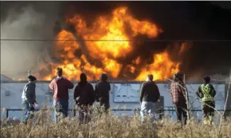  ?? MATHEW MCCARTHY PHOTOS, RECORD STAFF ?? People watch as firefighte­rs battle a blaze at Sheffield Street near Clemens Avenue in Hespeler on Monday afternoon.