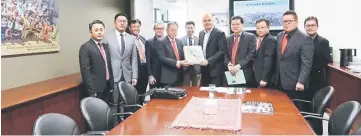  ??  ?? Dr Richard Tan (fifth left) presenting a souvenir to Nazaruddin during a courtesy visit in Perth.