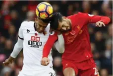  ?? JASON CAIRNDUFF/REUTERS ?? Watford’s Etienne Capoue and Liverpool’s Emre Can contest a high ball at Anfield on Sunday. Liverpool won 6-1 to top the Premiershi­p standings.