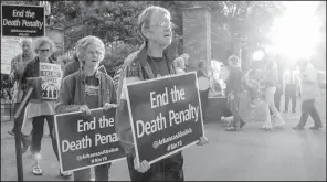  ?? Arkansas Democrat-Gazette/JOHN SYKES JR. ?? Members and supporters of the Arkansas Coalition to Abolish the Death Penalty sing “We Shall Overcome” while participat­ing in a vigil Thursday night outside the Governor’s Mansion in Little Rock.