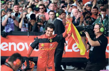  ?? AFP ?? Special one: Ferrari’s Spanish driver Carlos Sainz Jr waves his national flag after winning the British Grand Prix at the Silverston­e motor racing circuit. This was his maiden F1 race win.