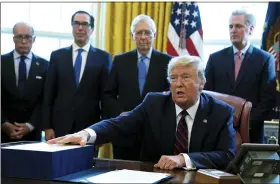  ?? EVAN VUCCI - THE ASSOCIATED PRESS ?? President Donald Trump speaks before he signs the coronaviru­s stimulus relief package in the Oval Office at the White House, Friday, March 27, in Washington. Listening are from left, Larry Kudlow, White House chief economic adviser, Treasury Secretary Steven Mnuchin, Senate Majority Leader Mitch McConnell, R-Ky., and House Minority Leader Kevin McCarty of Calif.