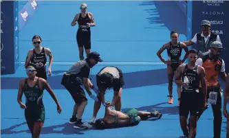  ?? JAE C. HONG THE ASSOCIATED PRESS ?? Mexico’s Cecilia Perez collapses after competing in a women’s triathlon test event at Odaiba Marine Park, a venue for marathon swimming and triathlon at the Tokyo 2020 Summer Olympics, Thursday.