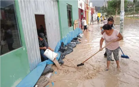  ??  ?? | FVecinos sacando agua de su vivienda. |