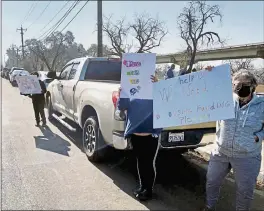  ?? PHOTO BY GABRIEL GRESCHLER ?? Protesters hold signs near the entrance of a homeless encampment on San Miguel Road in Concord on Sunday. All 25individu­als at the encampment must leave by Wednesday.