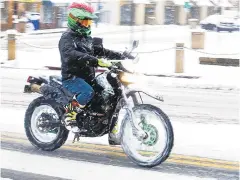  ??  ?? A motorcycli­st takes on the falling snow in Annapolis.