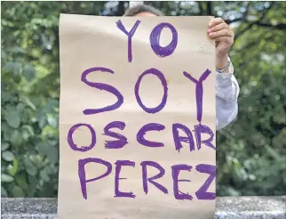  ?? MIGUEL GUTIÉRREZ / EFE ?? Rechazo. Una mujer muestra este cartel en protesta por la muerte de Óscar Pérez en manos del Gobierno.
