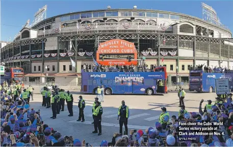  ?? AP FILE PHOTO ?? Fans cheer the Cubs’World Series victory parade at Clark and Addison on Nov. 4.