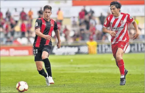  ??  ?? DISPUTA. Alfred Planas trata de hacerse con un balón ante la presión de Giorgi durante el Reus-Girona de ayer en el Estadi Municipal.