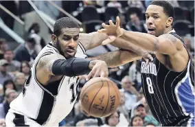  ?? AP ?? San Antonio Spurs forward LaMarcus Aldridge (12) and Orlando Magic forward Channing Frye (8) reach for a loose ball during the second half of an NBA basketball game on Monday night in San Antonio. San Antonio won 107-92.