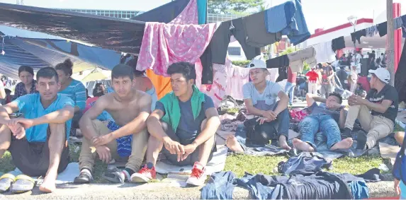  ??  ?? Migrantes hondureños que se dirigen a Estados Unidos descansaro­n ayer en la localidad de Huixtla, en Chiapas.