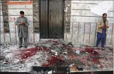  ?? AP PHOTO ?? Afghans stand outside a voter registrati­on centre after a suicide attack in Kabul yesterday.