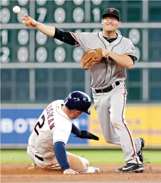  ?? AP Photo/Michael Wyke ?? ■ Houston Astros Alex Bregman (2) is out at second base as San Francisco Giants second baseman Kelby Tomlinson tries to turn the double play Wednesday during the fifth inning in Houston. See Page 4B.