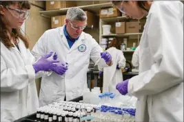  ?? PHOTOS BY JOSHUA A. BICKEL — THE ASSOCIATED PRESS ?? Eric Kleiner, center, sorts samples for experiment­ation as part of drinking water research at the U.S. Environmen­tal Protection Agency Center For Environmen­tal Solutions and Emergency Response in Cincinnati on Feb. 16.