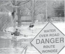  ??  ?? Fredericto­n residents return from checking on their flooded houses.