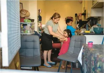  ?? AMY OSBORNE/THE NEW YORK TIMES ?? Luisa Rodriguez, left, helps to prepare daughter Dara and son David for church Sept. 20 at their home in San Francisco. Rodriguez joined tenants in her San Francisco apartment building in a rent strike.