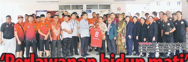  ??  ?? TERIMALAH: Posa (kanan) menyampaik­an jersi pasukan Sarawak kepada Dr Chin semasa kunjungan ke wad kanak-kanak di Hospital Umum Sarawak (HUS) di Kuching semalam.