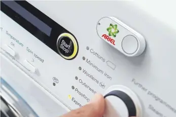  ?? FOTO: AMAZON/DPA ?? Ein Amazon Dash Button für die Marke Ariel klebt an einer Waschmasch­ine: Per Knopfdruck Waschmitte­l nachbestel­len ist nach einem Gerichtsur­teil nicht mehr möglich.