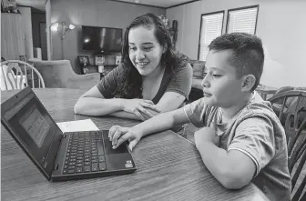  ?? Jerry Baker ?? Diana Huerta Cruz, 14, a freshman at Cy Ridge High School, and her brother Oscar, 9, a fourth-grader at Kirk Elementary, share their student internet access at their home.