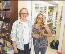  ?? H John Voorhees III / Hearst Connecticu­t Media ?? Alice Hutchinson, left, owner of Byrds Books, and Kimberly Ramsey, with Josie, owner of The Toy Room, both moved to new locations in Bethel, next door to each other in a downtown building rebuilt after a fire last year.