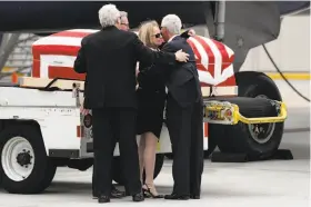  ?? Gregory Bull / Associated Press ?? Deborah Crosby hugs her brother John in front of their father’s casket after its arrival at the San Diego airport as brothers Douglas (left) and Steven look on.