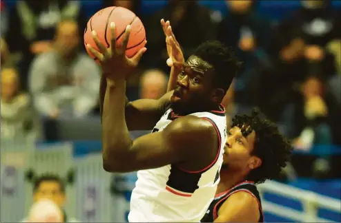  ?? Tyler Sizemore / Hearst Connecticu­t Media ?? UConn forward Adam Sanogo, left, grabs a rebound over Delaware State’s Kyle Johnson on Sunday.