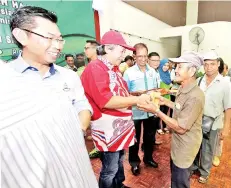  ??  ?? SALAH seorang penerima menerima bantuan daripada Anifah sempena majlis itu.