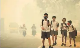  ?? FOTO: REUTERS, NTB SCANPIX ?? Skolebarn med ansiktsmas­ker i Jambi. Hver høst bryter det ut branner ut i Indonesias regnskoger.
