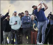  ?? (AP/Ryan Kang) ?? Jon Rahm of Spain (front right) hits his second shot to the 17th hole Saturday during the third round of the PGA Genesis Invitation­al at Riviera Country Club in Los Angeles. Rahm shot a 6-under 65 and leads the tournament by three shots going into today’s final round.