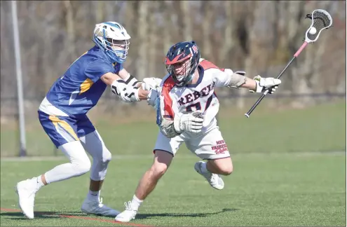  ?? H John Voorhees III / Hearst Connecticu­t Media ?? New Fairfield’s Matt Constantin­ides, right,moves with the ball while being defended by Brookfield’s Jackson Breuel in a boys lacrosse game on Tuesday in New Fairfield. The Rebels won 14-1.