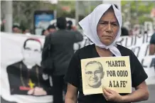  ?? SALVADOR MELENDEZ/ THE ASSOCIATED PRESS ?? A woman carries a portrait of slain Roman Catholic Archbishop Oscar Romero that reads in Spanish: ‘Martyred by faith haters,’ during a protest Thursday in El Salvador.