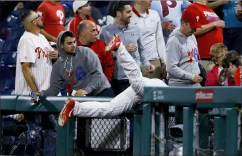  ?? MATT SLOCUM — THE ASSOCIATED PRESS ?? Phillies first baseman Rhys Hoskins falls into the stands after chasing a foul ball by Milwaukee’s Orlando Arcia during the eighth inning Wednesday night. The Brewers won, 5-2.