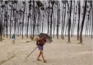  ??  ?? COX’S BAZAR: A Bangladesh­i villager evacuates to a cyclone shelter on the coast yesterday. —AFP