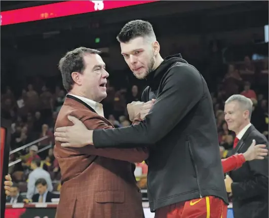  ?? Gina Ferazzi Los Angeles Times ?? MIKE BOHN, congratula­ting Nick Rakocevic before USC’s victory over UCLA last Saturday, was praised for his actions as the coronaviru­s outbreak hit home.