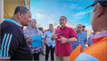  ?? ?? Adly (centre) interacts with some of the visitors attending the Alor Gajah Parliament Rahmah Carnival. — Bernama photo