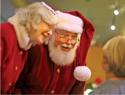  ?? STAFF PHOTO BY C.B. SCHMELTER ?? Santa Claus, played by Jim Trubey, and Mrs. Claus, played by Jenny Matlock, meet 6-year-old Hayes Grinnell at Station House on Friday in LaFayette, Ga. Trubey is returning to Erlanger hospital on Christmas morning as Santa to give back to the hospital...