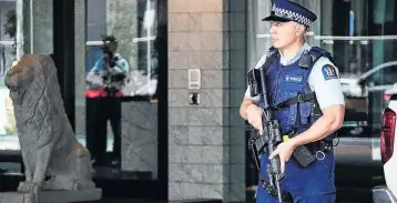  ?? PHOTO: THE NEW ZEALAND HERALD ?? Armed police stand guard outside the Sofitel Hotel in Auckland on Thursday after a shooting incident.