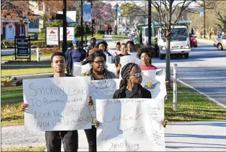  ?? HYOSUB SHIN / HSHIN@AJC.COM ?? Students including Peyton Holston (left), 18, and Fatine Niane (right), 16, walk through downtown Jonesboro to demonstrat­e against tobacco’s deadly effects last March. Young people’s use of electronic cigarettes “has reached an epidemic proportion,” the FDA chief said.