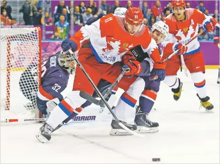  ?? MARK HUMPHREY/ASSOCIATED PRESS FILE PHOTO ?? Russia forward Yevgeni Malkin seals off the puck from USA defenseman Ryan McDonagh during a game at the 2014 Winter Olympics in Sochi, Russia. The NHL announced Wednesday it is withdrawin­g from the Beijing Olympics after the regular-season schedule was disrupted by coronaviru­s outbreaks. The league will use the previously scheduled Feb. 6-22 Olympic break to make up postponed games.