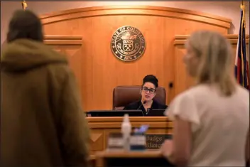  ?? HYOUNG CHANG — THE DENVER POST ?? Chief Judge Susan Blanco of the 8th Judicial District, center, talks with a defendant, foreground left, and their public defender Tracy Lowrey, foreground right, in a courtroom at the Larimer County Justice Center in Fort Collins on Oct. 26.