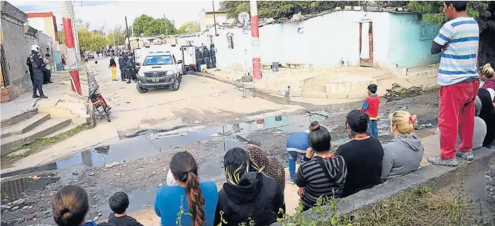  ?? (JAVIER FERREYRA) ?? Crimen. Ayer a la tarde, grandes y chicos miraban en silencio cómo retiraban el cadáver de la mujer. Por lo bajo, varios aseguran que habrá más tiros en las próximas horas.