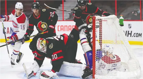  ?? THE CANADIAN PRESS ?? Senators right-winger Drake Batherson slams Montreal Canadiens left-winger Tomas Tatar into the net iin the first period action at the Canadian Tire Centre on Tuesday.