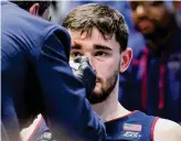  ?? Aaron Doster/ Associated Press ?? UConn’s Alex Karaban sits on the bench as he is tended to for an injury by associate head athletic trainer James Doran during the second half against Xavier on Jan. 10.