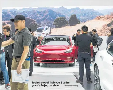  ?? Photo / Bloomberg ?? Tesla shows off its Model 3 at this years’s Beijing car show.