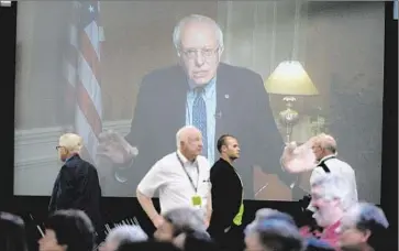  ?? Darren McColleste­r
Getty Images ?? SEN. BERNIE SANDERS, on screen, urged everyone to work together for solutions. “Yeah, there are going to be big disagreeme­nts,” he said. “Let’s not try to demonize people who may have disagreeme­nts with us.”