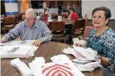  ?? Elizabeth Conley photos / Houston Chronicle ?? Benny Mitschke and Jan Reister flatten out plastic grocery bags that will be cut up and used as plarn.