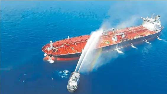  ?? AFP ?? Problemas. Un buque cisterna es auxiliado en el estrecho de Ormuz luego de haber sufrido un principio de incendio en una de sus cubiertas.