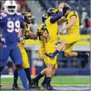  ?? IMAGES GETTY ?? Garrett Moores (hands on helmet), Quinn Nordin (right) and Michigan celebrate a field goal Saturday in Arlington, Texas. Nordin kicked four in a win over Florida.