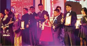  ??  ?? SHAMSIR (dua dari kanan) menerima Anugerah Peniru Suara Kartun Terbanyak untuk Kategori Seni dan Hiburan menerusi Malam Anugerah Malaysia Book of Records 2014.
